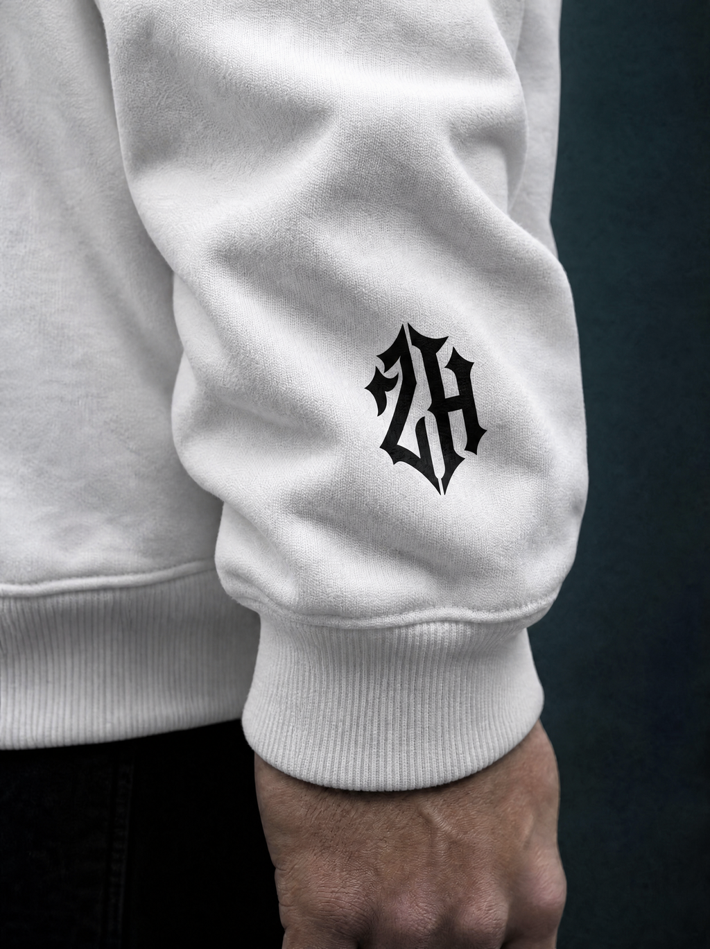 White sweatshirt with a black logo on a dark background