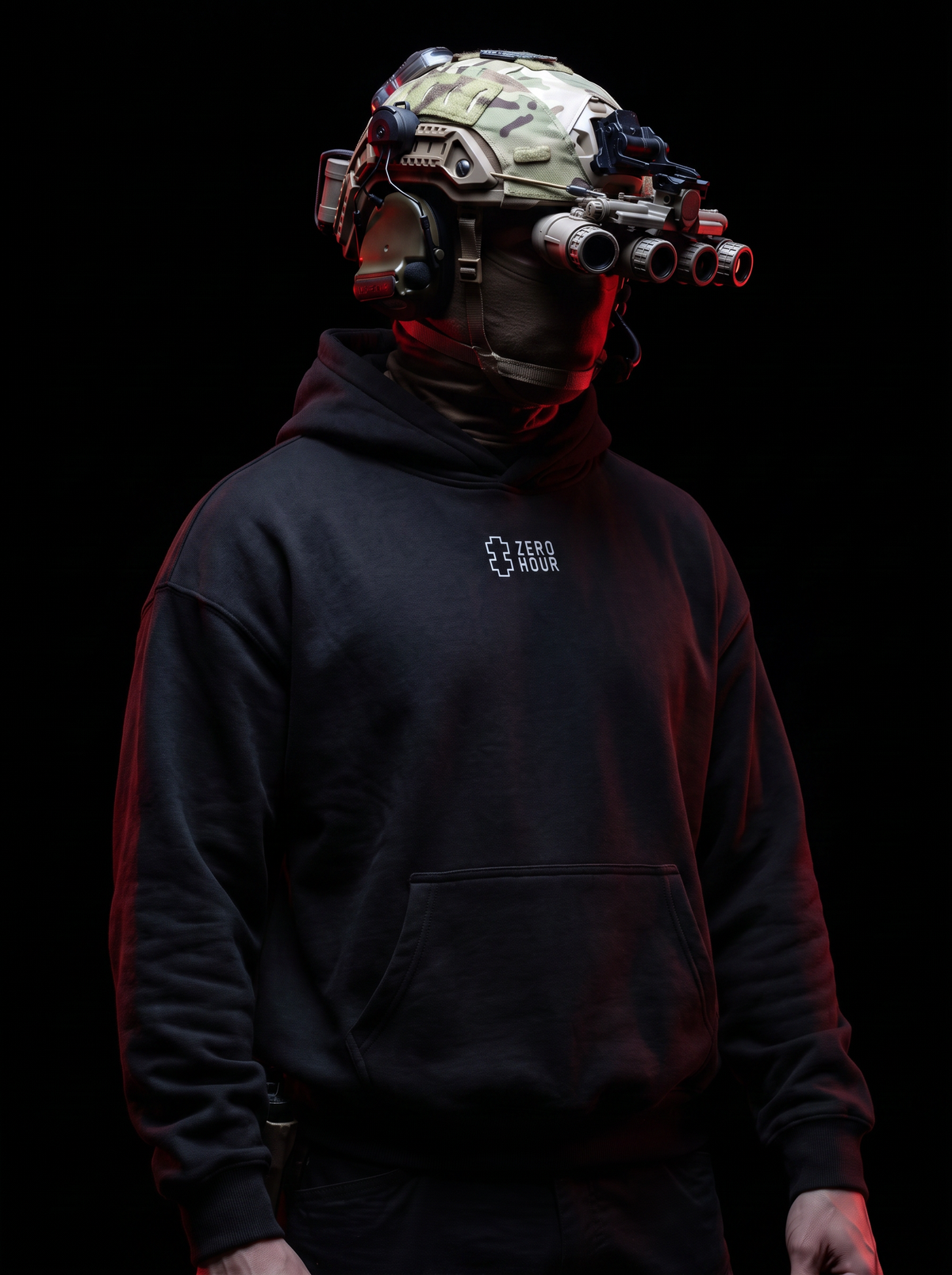 A person wearing a black hoodie with a small white 'ZERO HOUR' logo on the chest, a black neck gaiter, and a tactical helmet with night vision goggles, set against a solid black background with dramatic red lighting.