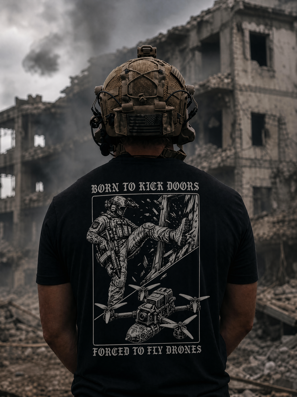 A man viewed from behind wearing a black graphic t-shirt with a white military-themed print and helmet, standing in front of a ruined concrete building with smoke in the background.