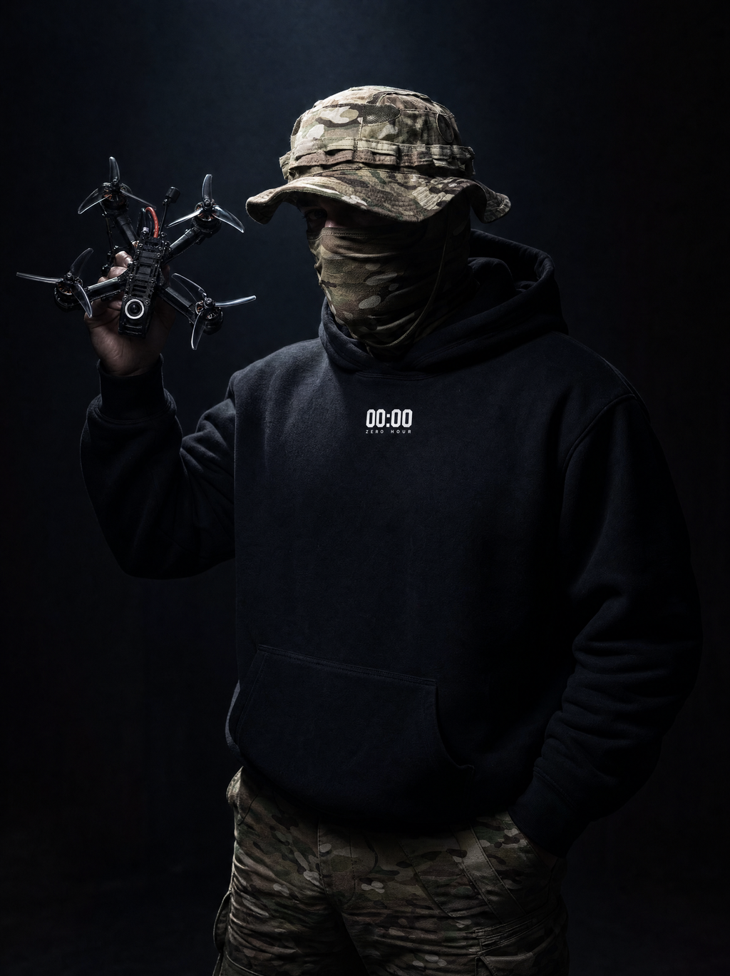 Person in camouflage gear holding a drone against a dark background