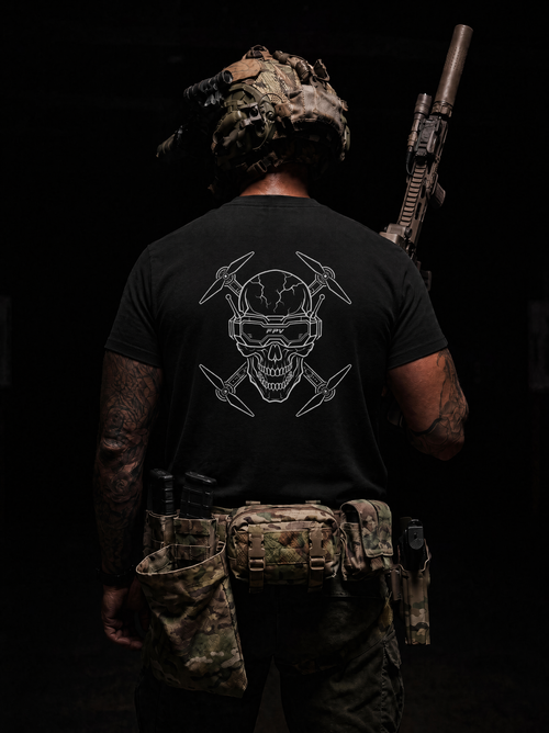 Person wearing a black t-shirt with a skull design, holding a rifle, on a dark background