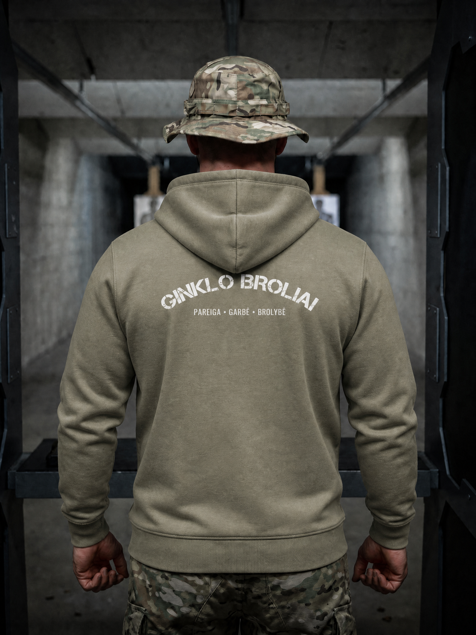 Person wearing a green hoodie with text on the back in an indoor setting