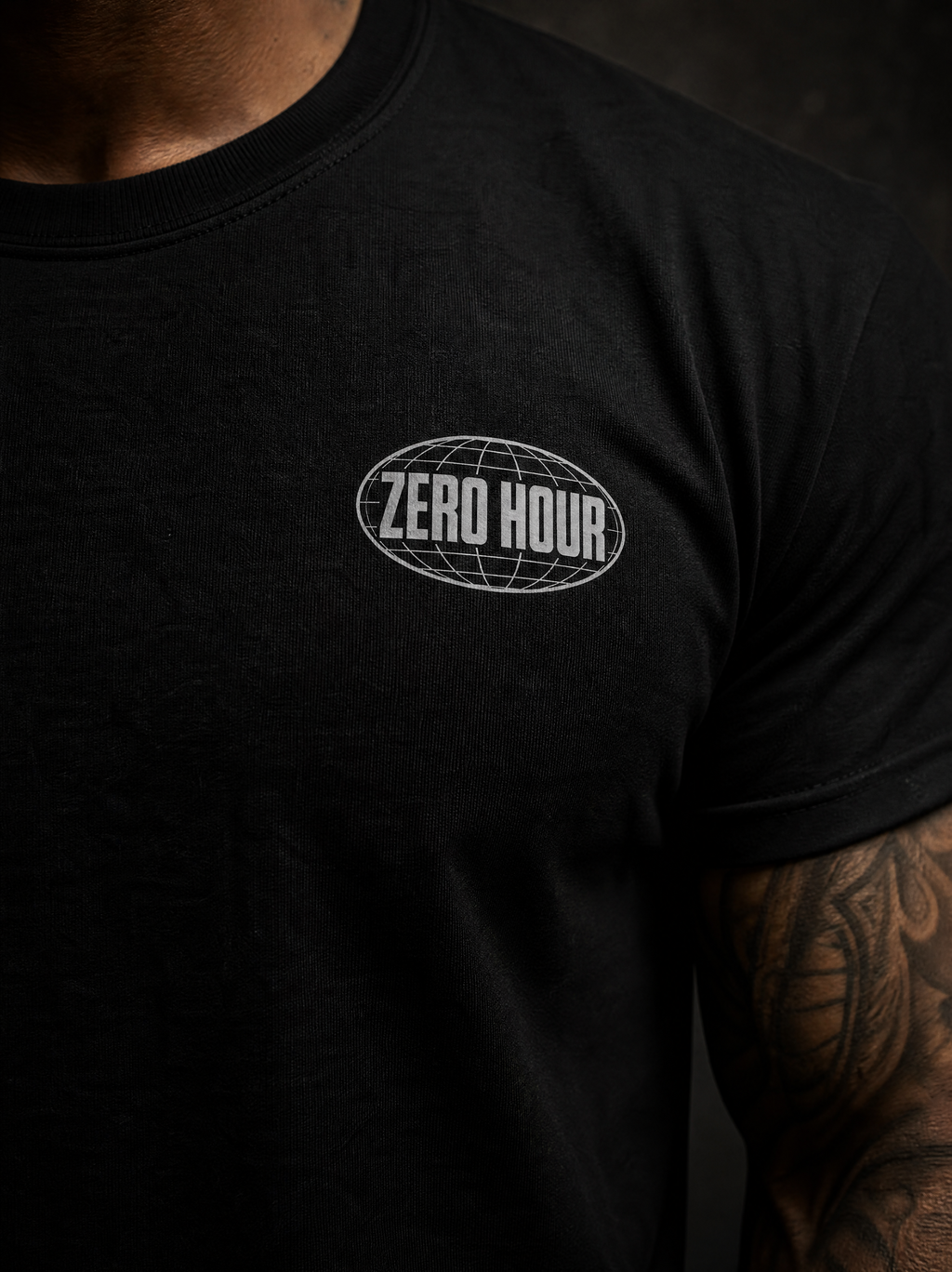 A close-up of a person wearing a black short-sleeve t-shirt with a white 'ZERO HOUR' oval globe graphic printed on the left chest.