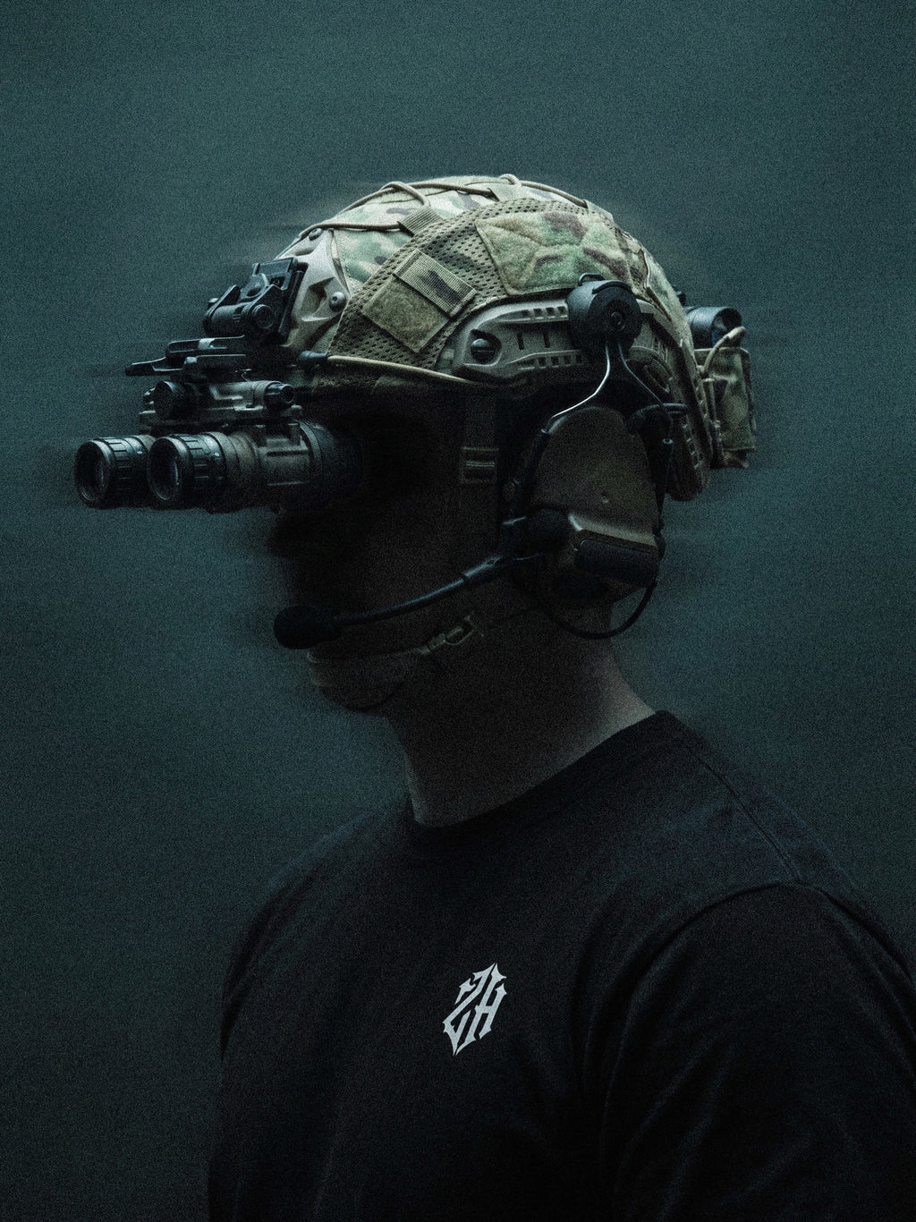 Person wearing a tactical helmet with night vision goggles on a dark background