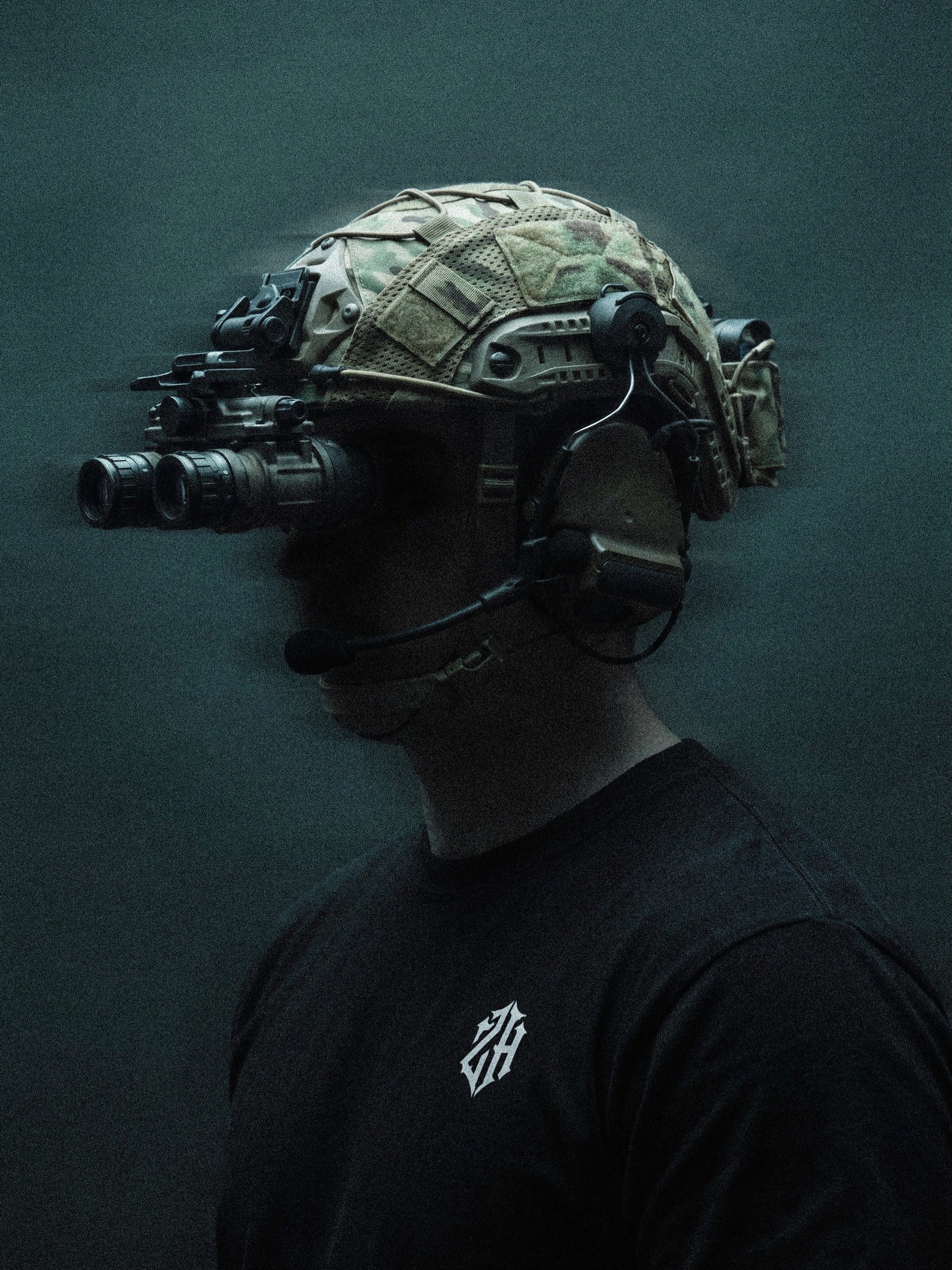 Person wearing a tactical helmet with night vision goggles on a dark background