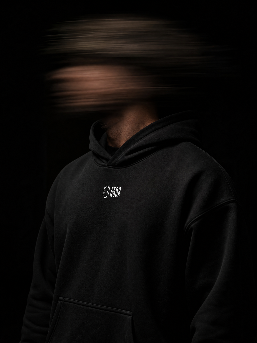 Person wearing a black hoodie with a Zero Hour logo on a dark background