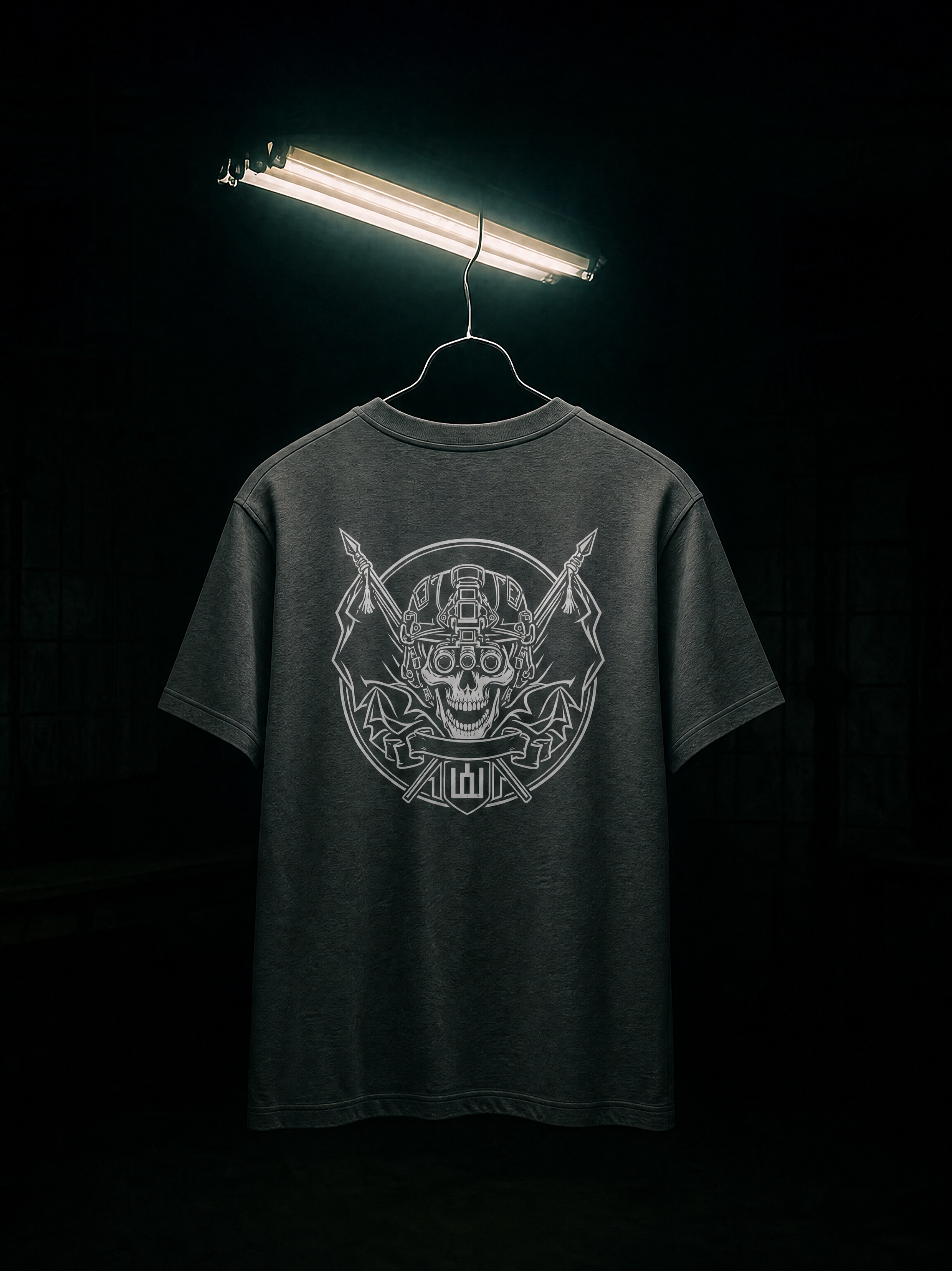 Black t-shirt with a graphic design on a hanger under a light source against a dark background