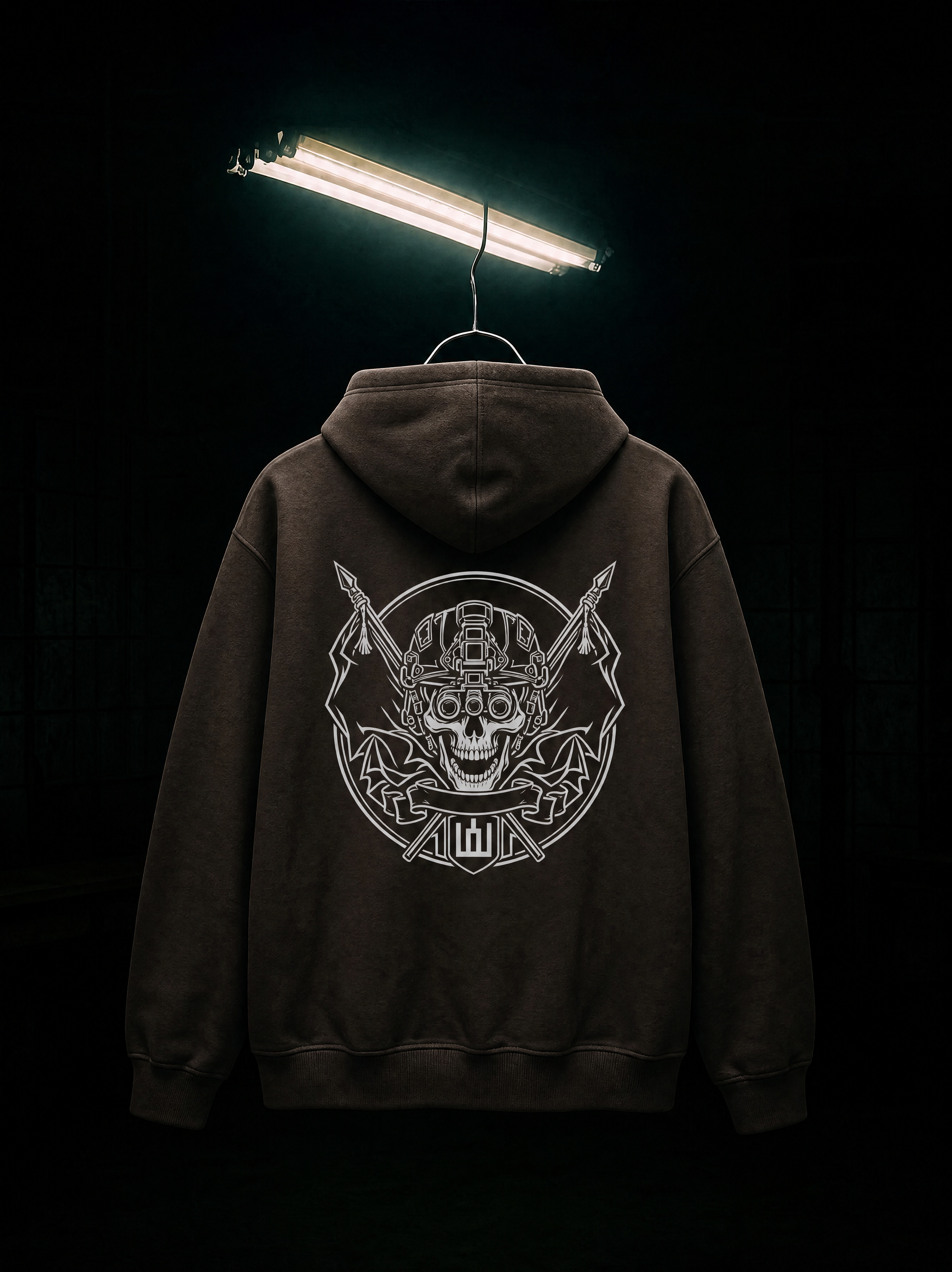 Black hoodie with a skull design on the back, hanging against a dark background.