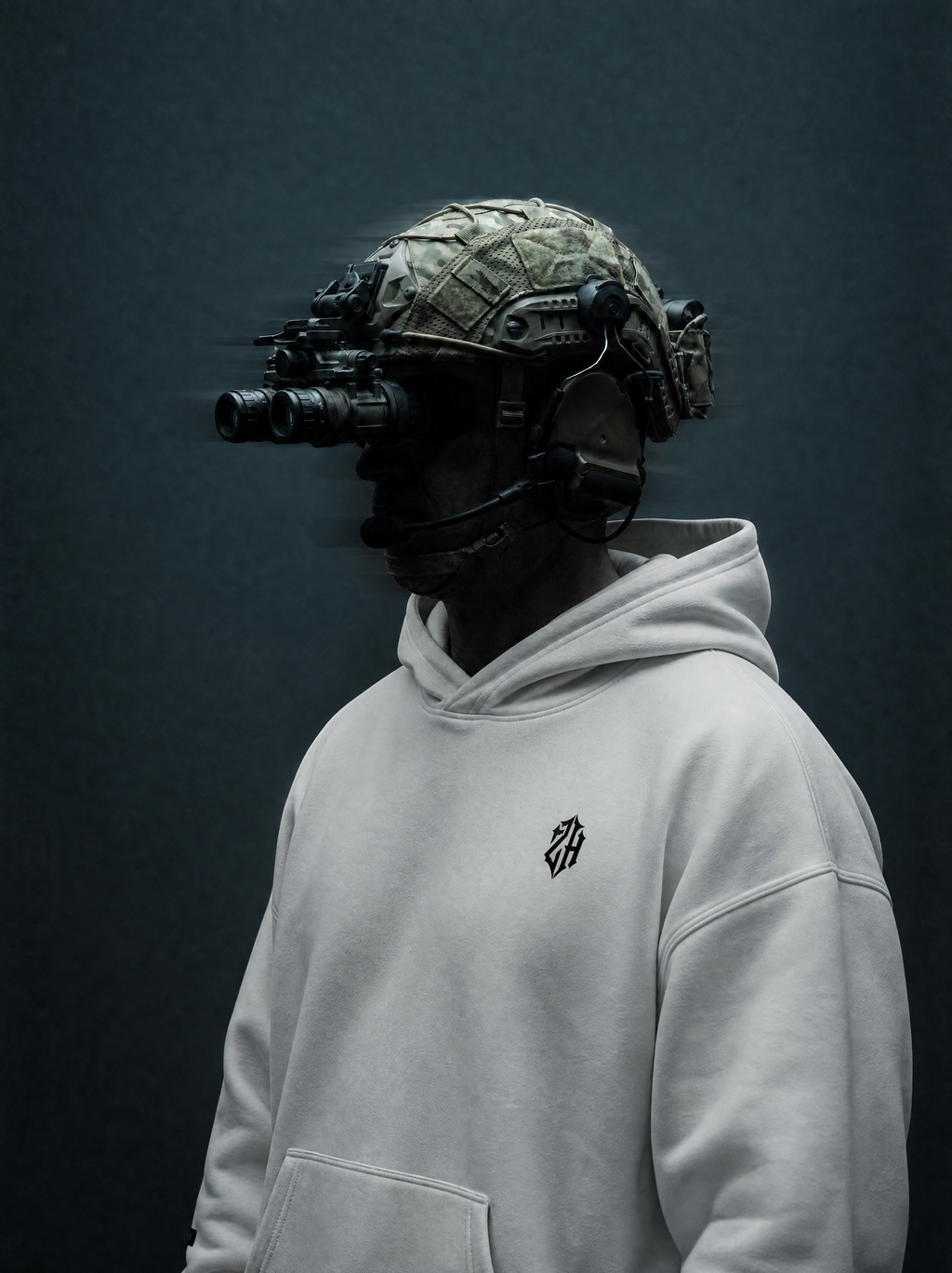 Person wearing a tactical helmet with night vision goggles and a gray hoodie on a dark background