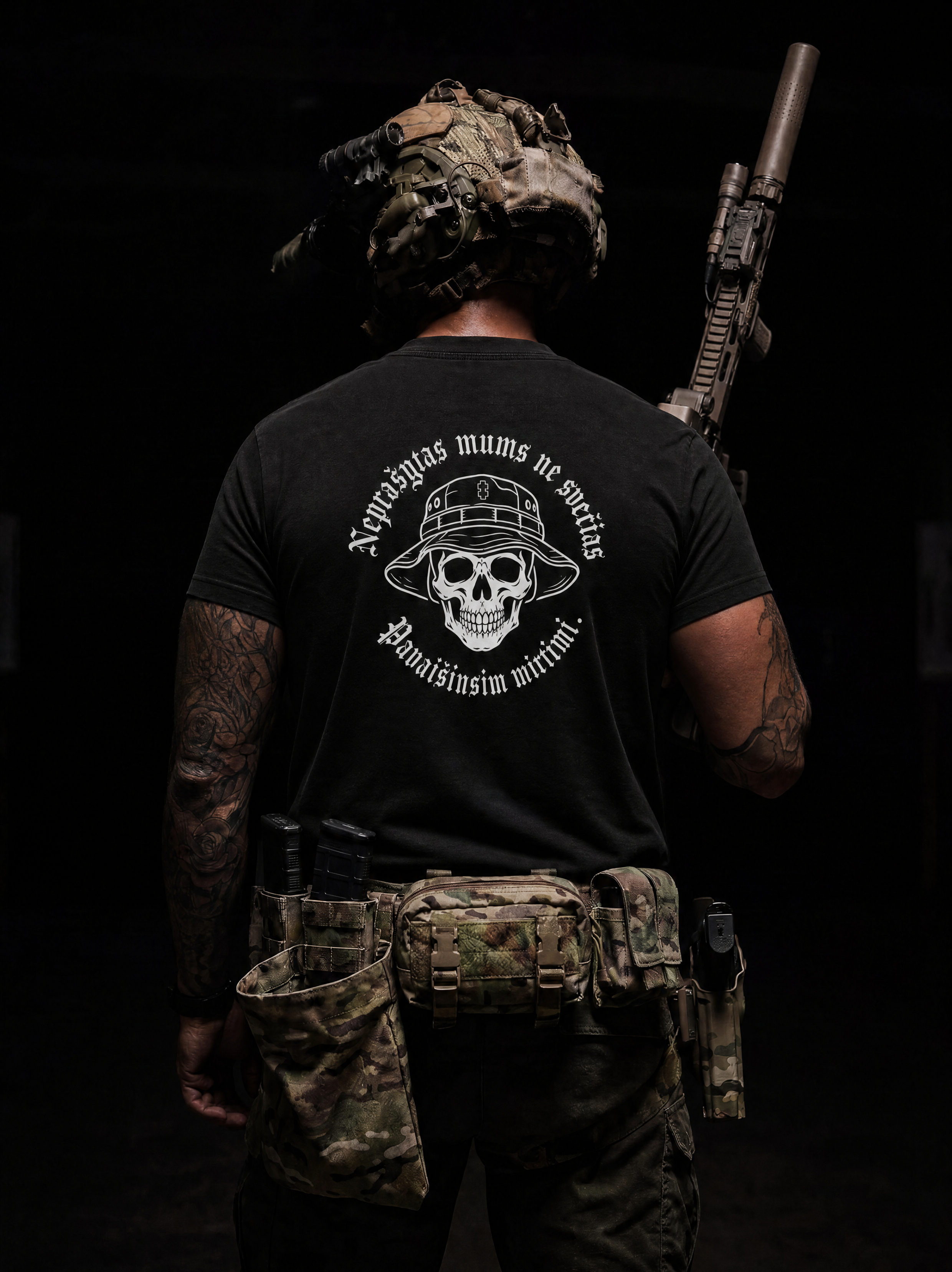 Person wearing a black t-shirt with a skull design and text, holding a rifle on a dark background