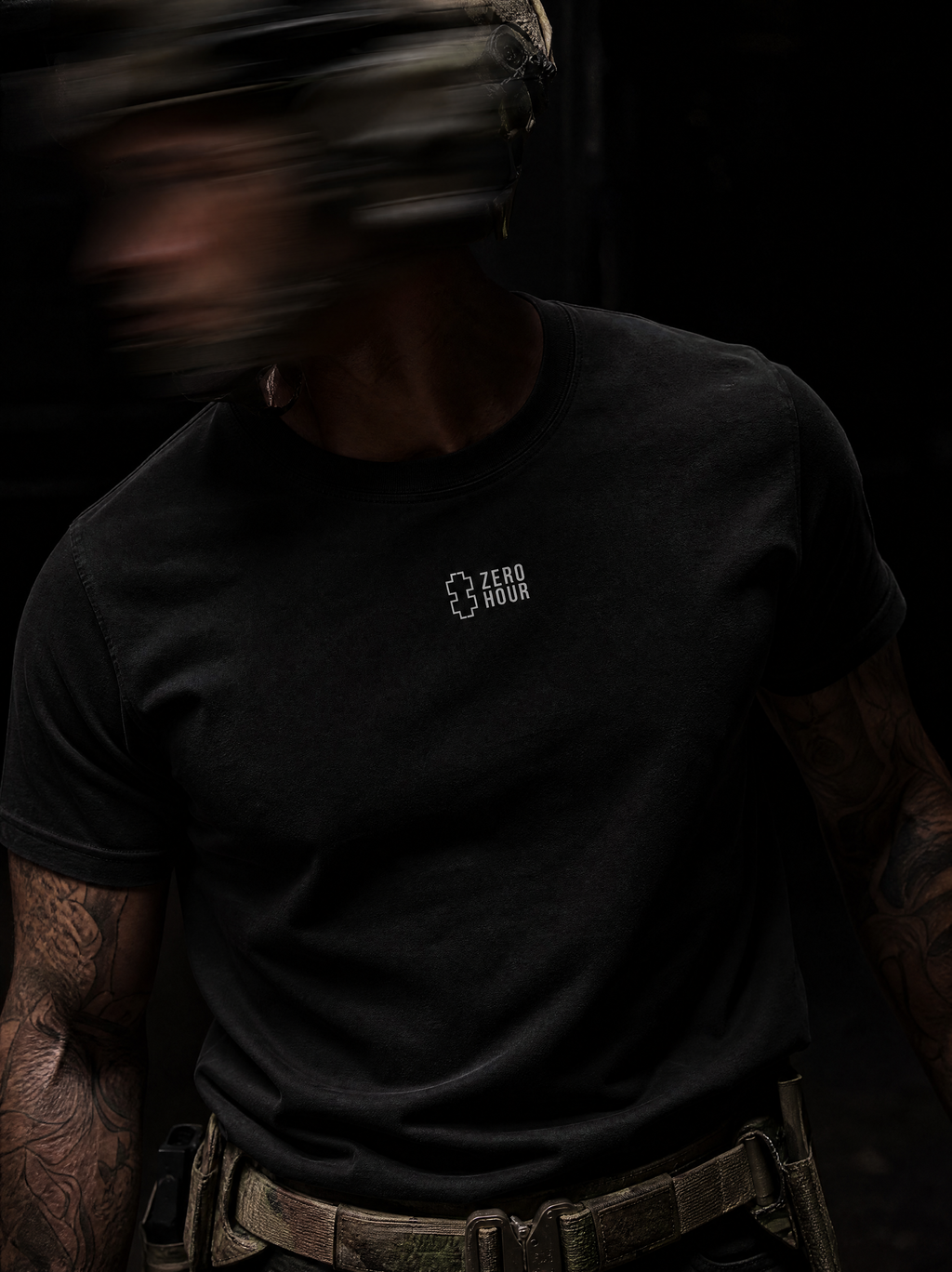 Person wearing a black t-shirt with a Zero Hour logo on a dark background